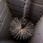 Процесс чистки, ерш опускается в печную трубу на веревке